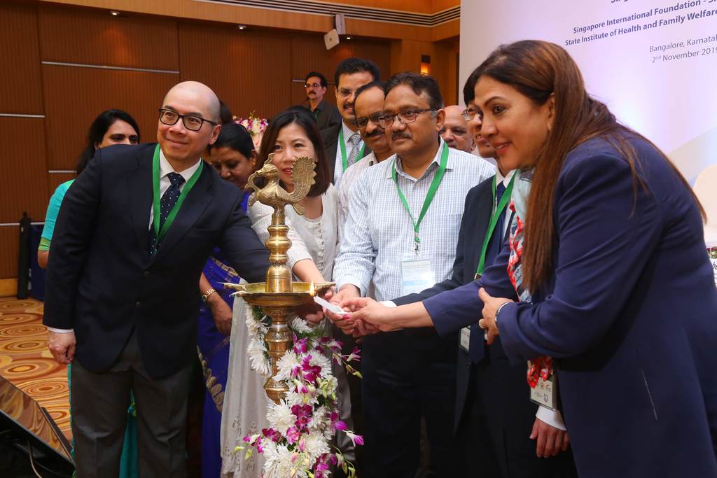 Mr Jawaid Akthar, Principal Secretary of Health (Health and Family Services) for the Government of Karnataka (Centre, with green lanyard) lights an Indian lamp as a customary gesture to kickstart the symposium
