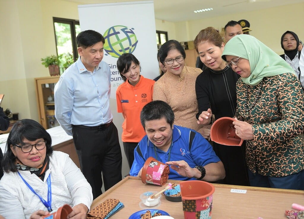 Singapore President Halimah Yacob (right) observing handicraft work by YPAC Jakarta students who are learning vocational skills to increase their job readiness. 