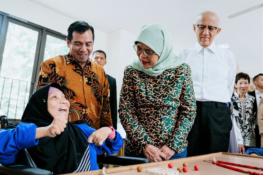 Managing director of YPAC Jakarta Mr Agoes Abdoel Rakhman (standing, left) introducing a YPAC student (bottom, left) to Singapore President Halimah Yacob (standing, centre) and her husband Mr Mohamed Abdullah Alhabshee (standing, in white) at the SIF's Occupational Therapy for Children with Special Needs project in Jakarta, Indonesia. 