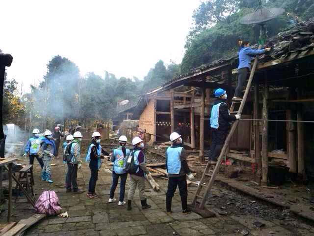 Helping villagers move tiles from damaged homes to their temporary shelters.