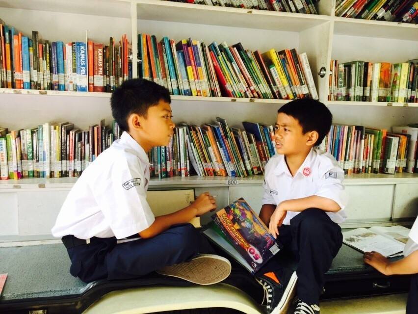 Boys from SMP 4 sharing some stories they’ve just discovered at the Words on Wheels mobile library.