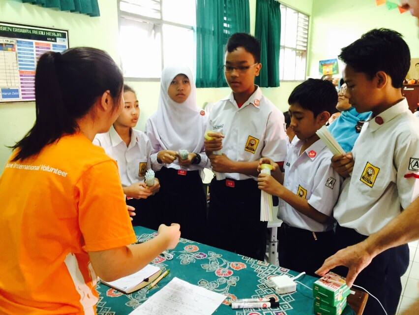 Students from Sekolah Menengah Pertama Negeri 4 (SMP 4) listen intently as Singapore International Volunteer Fiona Lee shares details on a teambuilding activity.