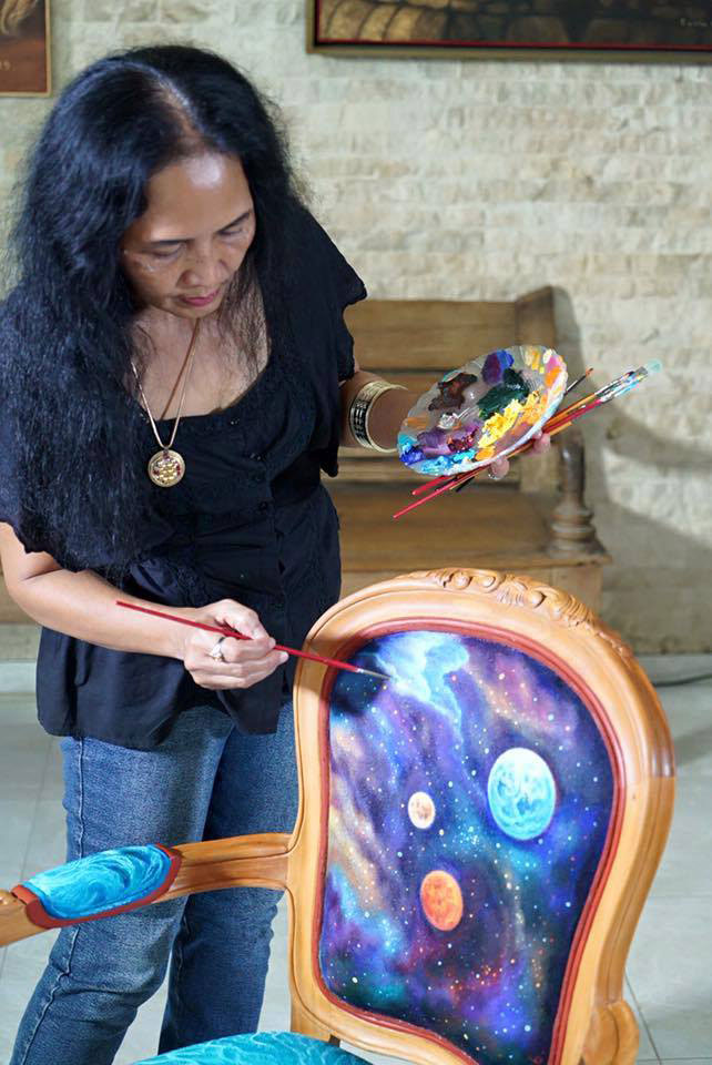 Indonesian artist Lucia Hartini painting her chair in preparation for the Chairity project.