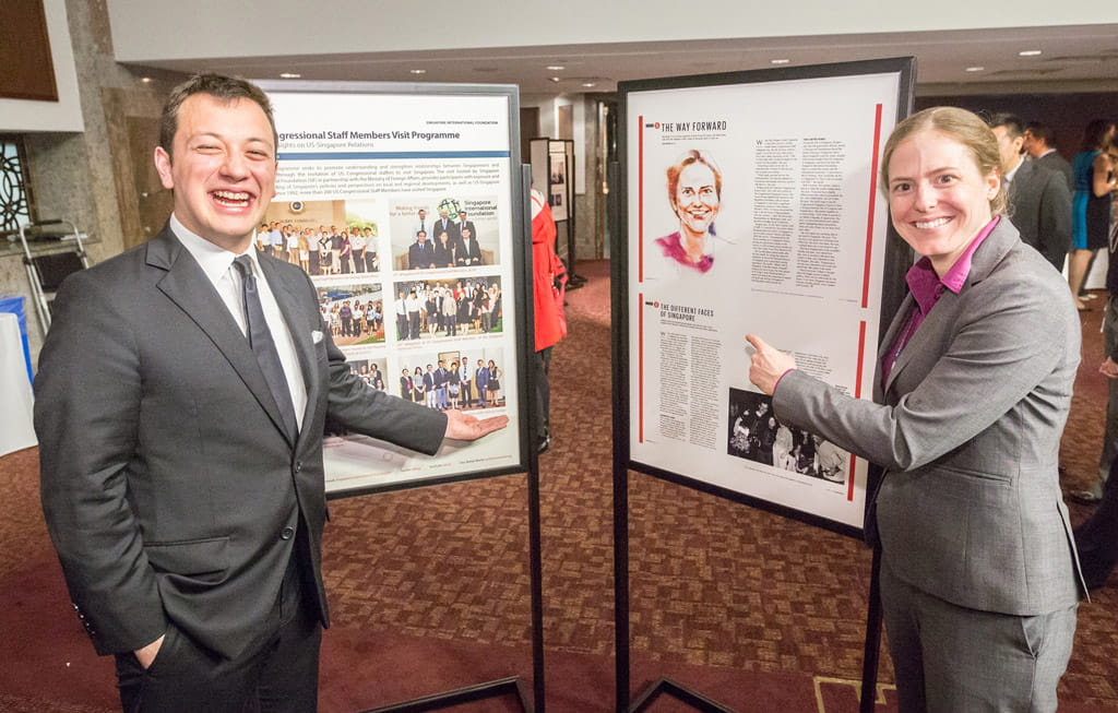 30th US Congressional Staffers Visit Programme alumni Mr Erik Ashida (left) and Ms Jami Burgess posing with their Singapore visit photograph and feature in the special SG50 edition of SINGAPORE Magazine, respectively.