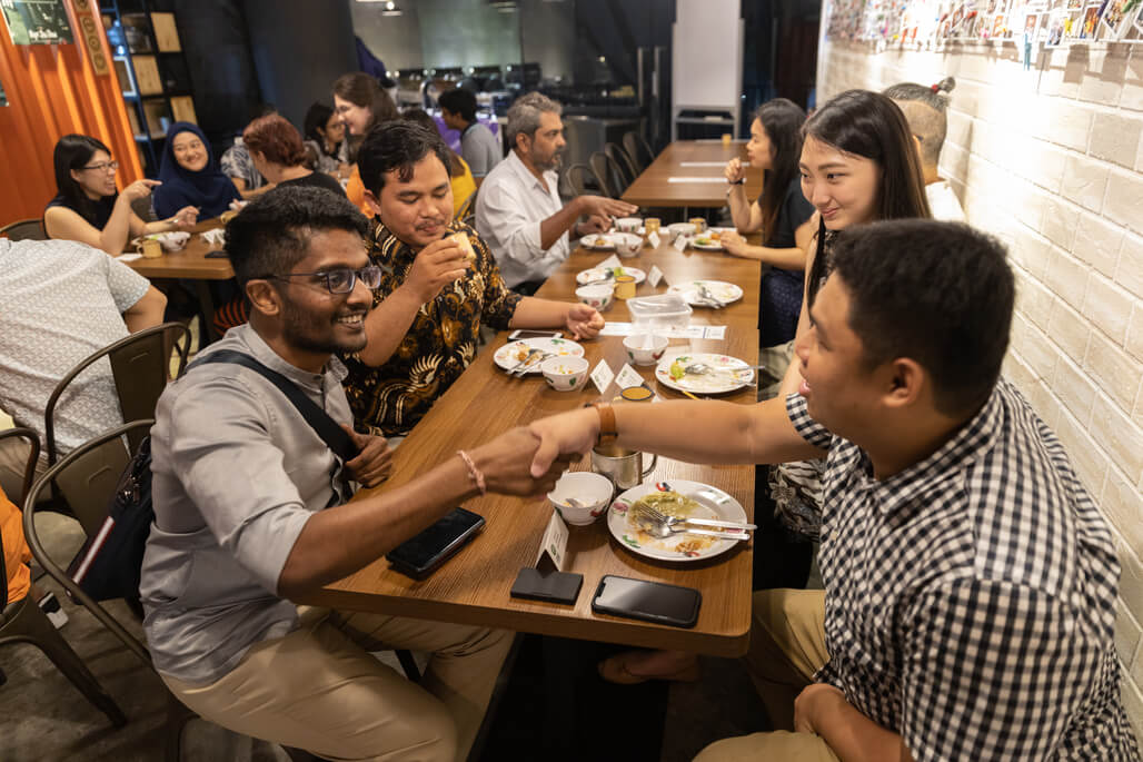 Singapore's Tamil Murasu journalist Vengadeshwaren Subramaniam (bottom left), together with Indonesian media, meeting Daniel Teh, the founder of social enterprise restaurant Pope Jai Thai. 