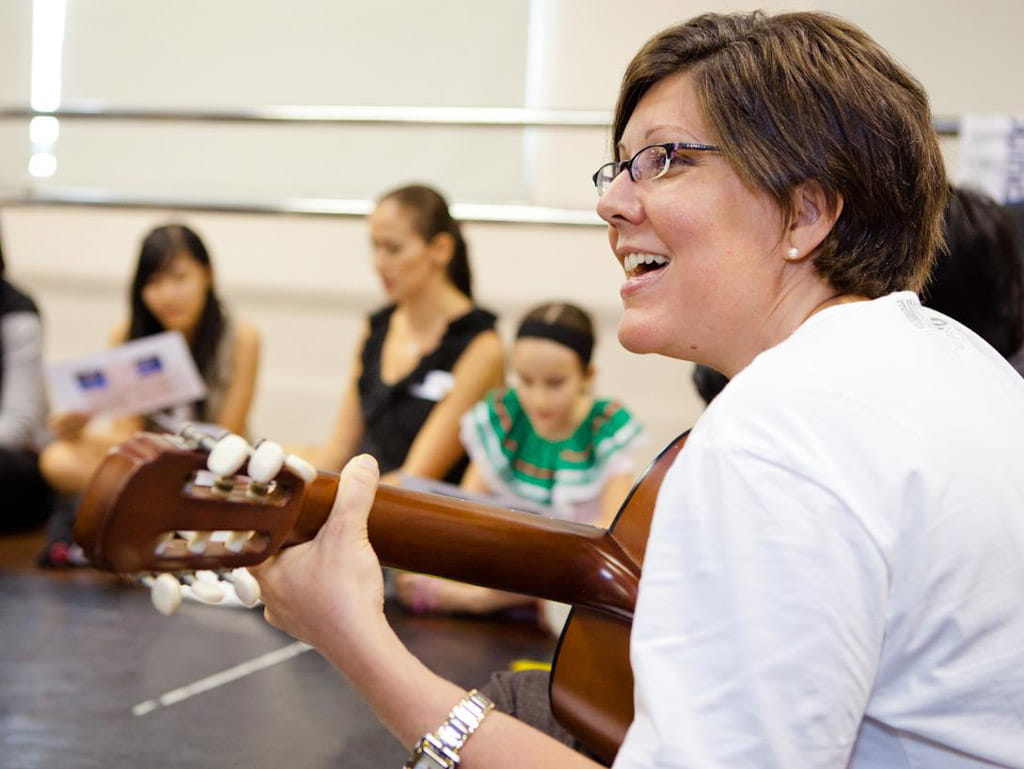 Claudia De Villegas, the wife of Mexican ambassador on her guitar, guiding the youths in singing Cielito Lindo, a traditional Mexican song.