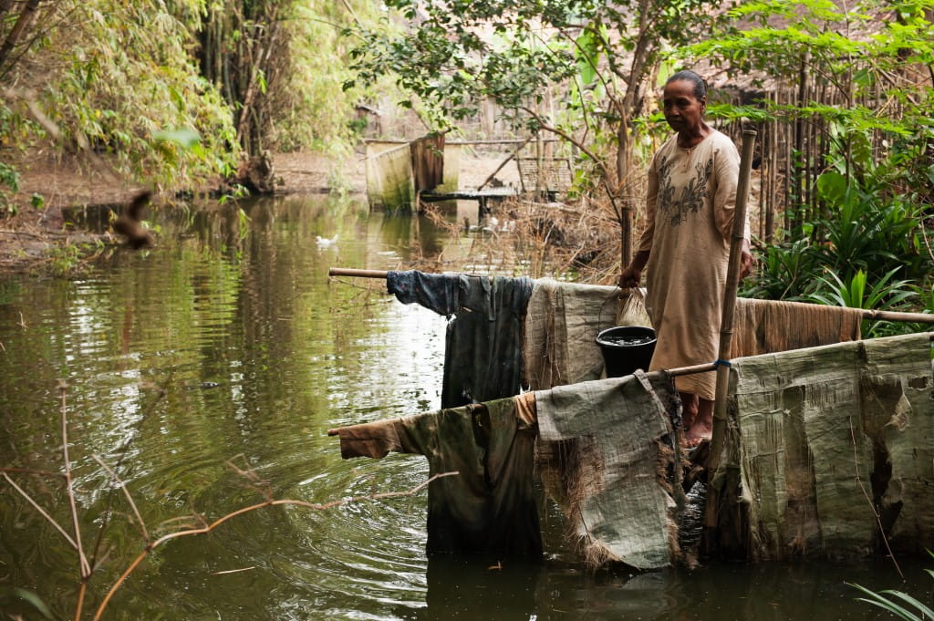Ibu Rupiah, a Desa Kebet resident collects water from her backyard. The pond has been used by her since childhood for several purposes, such as bathing, washing clothes and collecting drinking water. Despite the dangers it pose, this was considered to be a common practice for Ibu Rupiah and so many others, because they had no choice. Now, with the water filter installed, she finally has access to clean drinking water.
