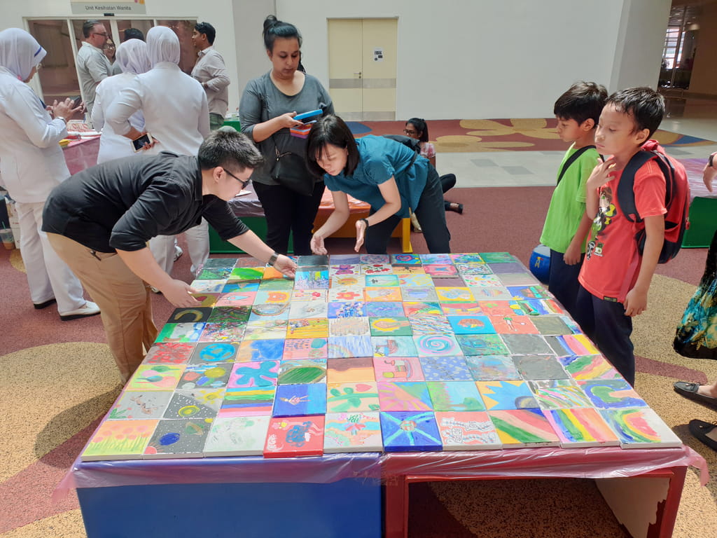 Art therapy students from Singapore's LASALLE College of the Arts facilitating a community art project in the Women's and Children's Hospital Kuala Lumpur as part of CausewayEXchange Festival. Over 200 canvases were painted by patients, families, nurses, doctors and contributors from Singapore and Malaysia.