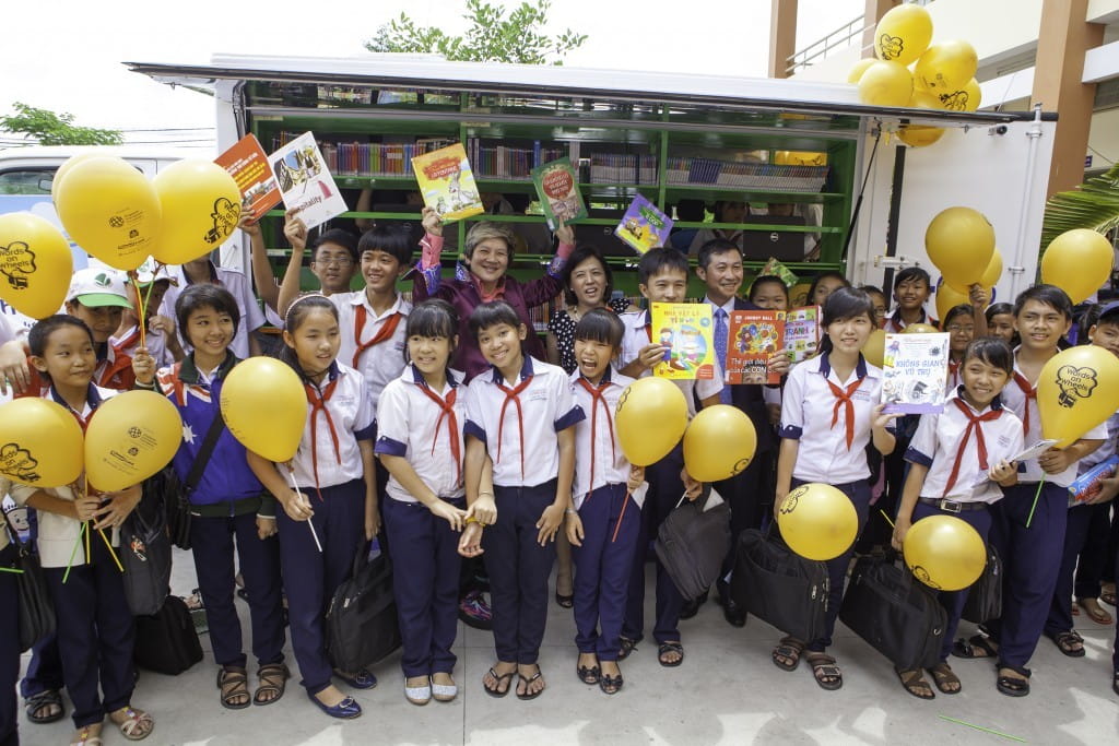 (Back Row, From Left) SIF Governor Ms Elim Chew, Keppel Land General Manager of Investor Relations & Research Ms Serena Toh and Keppel Land Vietnam General Manager Mr Doan Anh Hung in front of the mobile library with some students from Le Minh Xuan Secondary School.