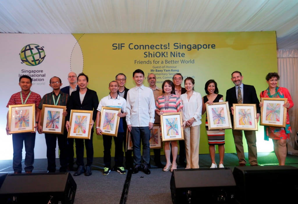 Guest-of-honour Parliamentary Secretary Mr Baey Yam Keng joins on stage for a commemorative group photo with award recipients recognised for their contributions to support the work of the SIF over the past few years.